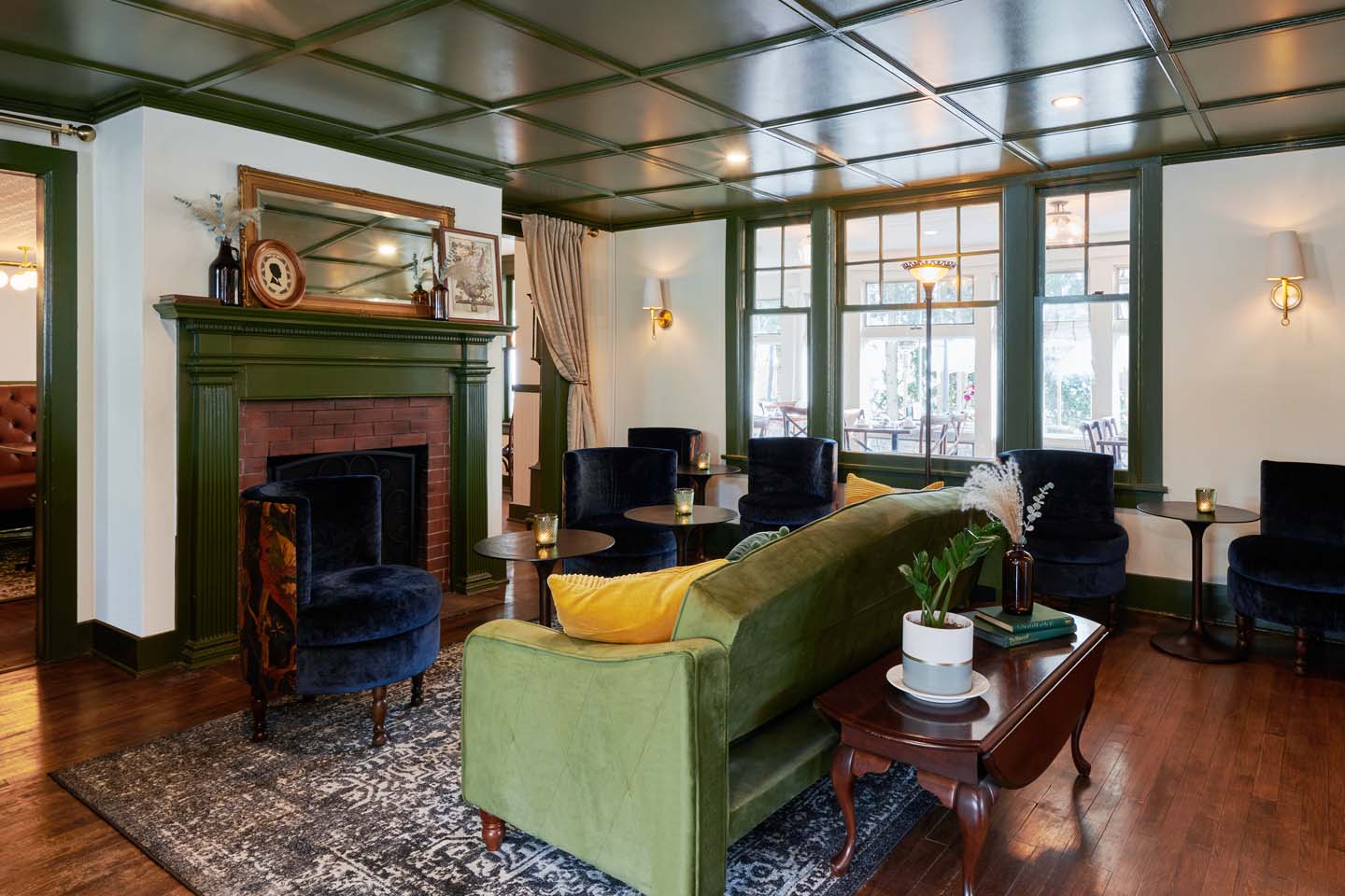 Lounge with green coffered ceiling and velvet sofa