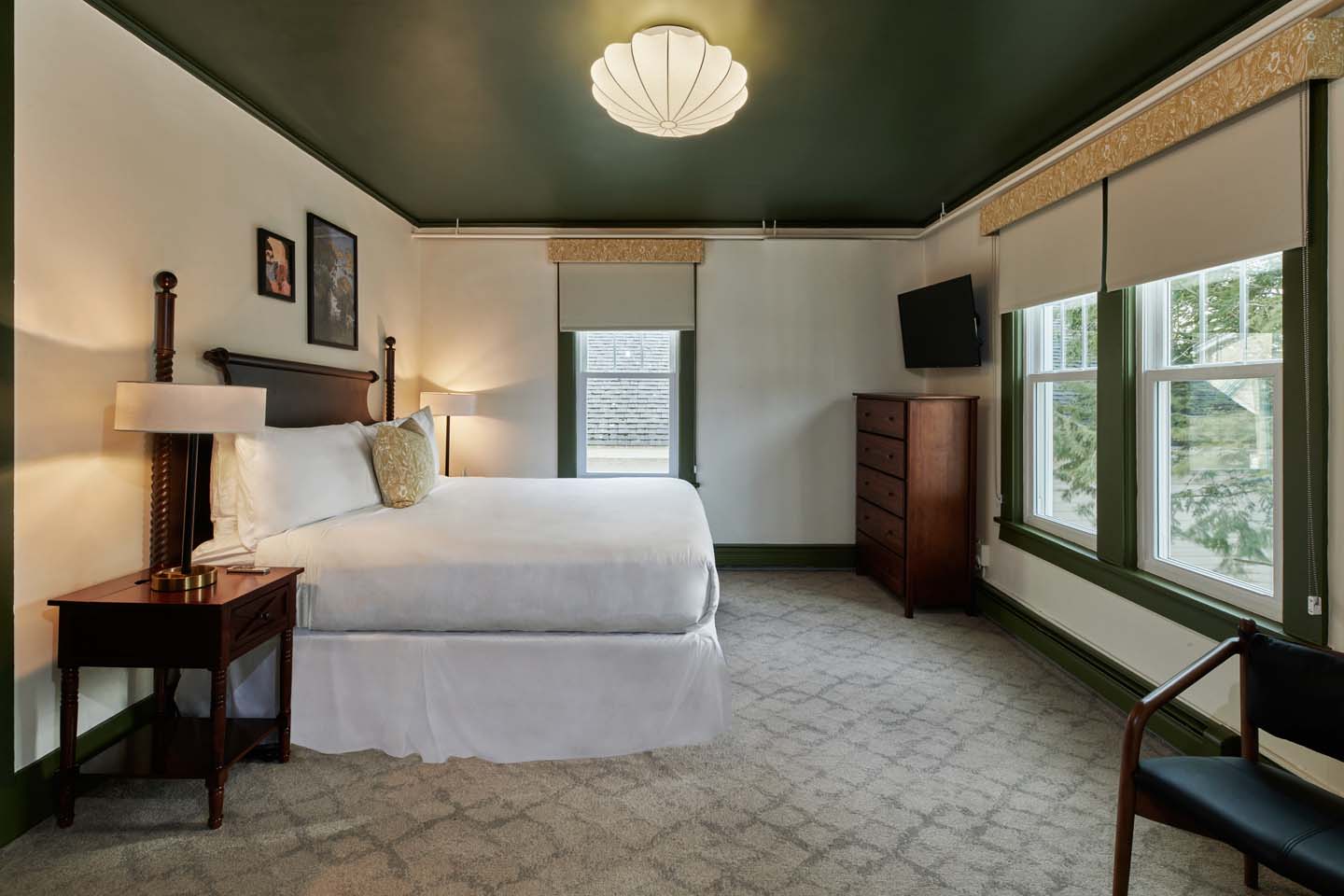 Quiet guest room with four-poster bed and tall windows