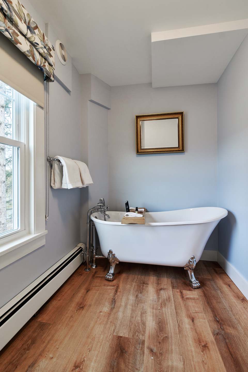Bathroom with clawfoot soaking tub by window