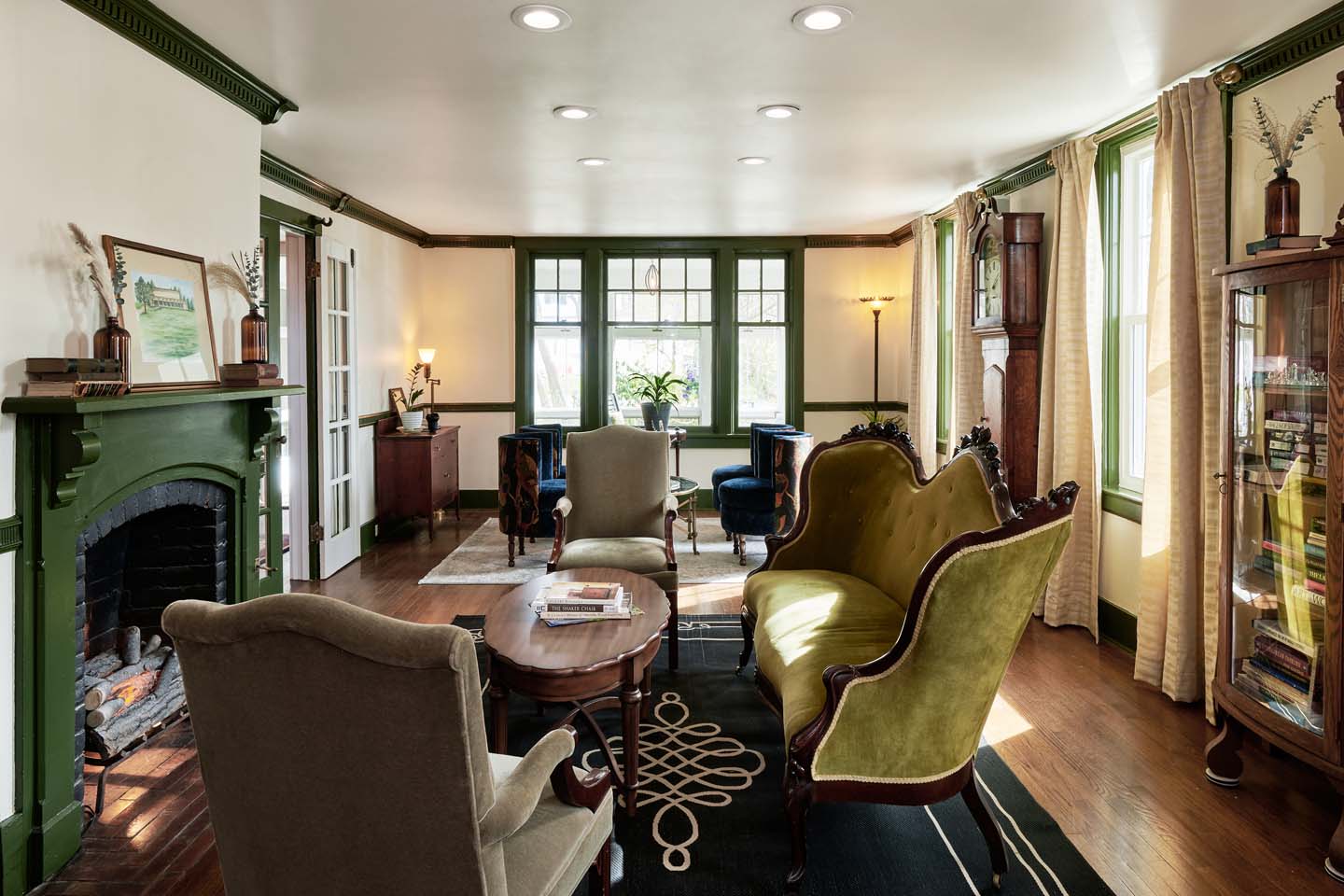 Garden parlor with green velvet sofa and fireplace