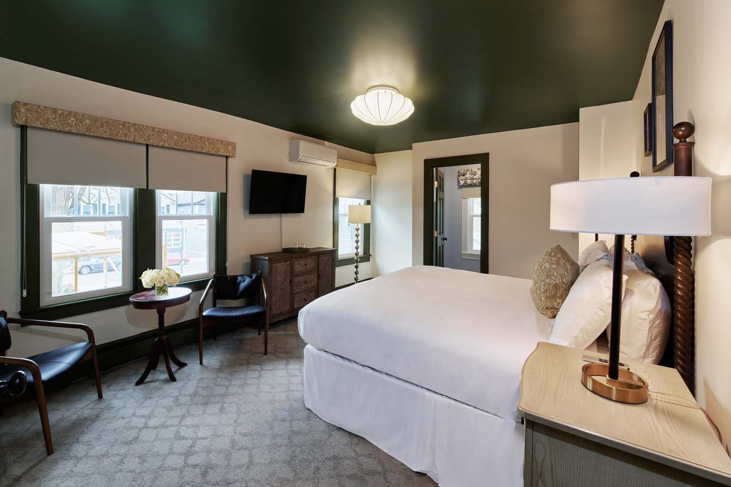 Guest room with green ceiling, leather chairs, and king bed